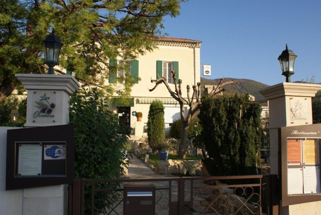 een huis met een hek ervoor bij Hôtel Restaurant Les oliviers in Nyons