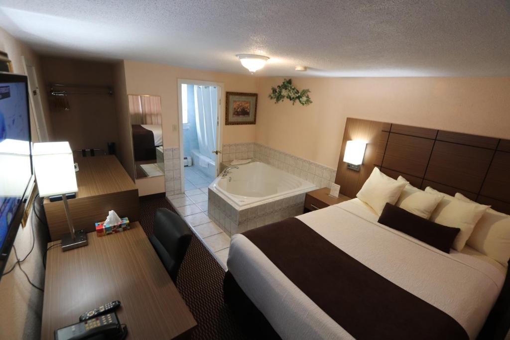 a hotel room with two beds and a television at Campbellford River Inn in Campbellford