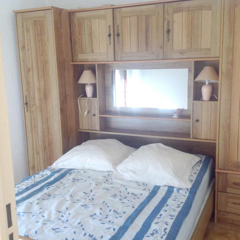 - une chambre avec un lit et des placards en bois dans l'établissement Appartement 2 chambres à Cavalaire-sur-Mer, 40 m² avec balcon, à Cavalaire-sur-Mer