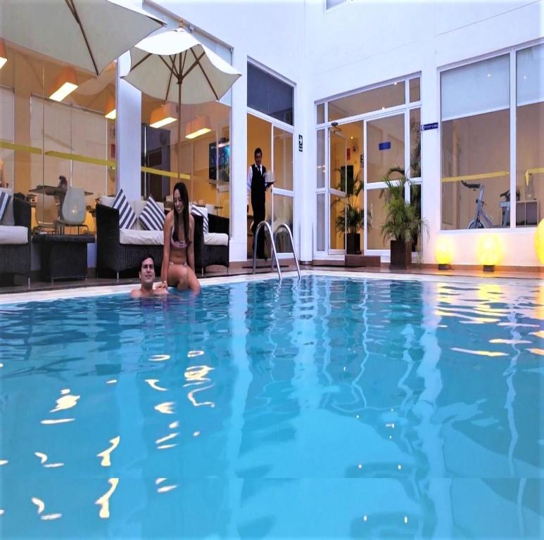 a woman and a child sitting in a swimming pool at Hotel Gran Palma Piura in Piura