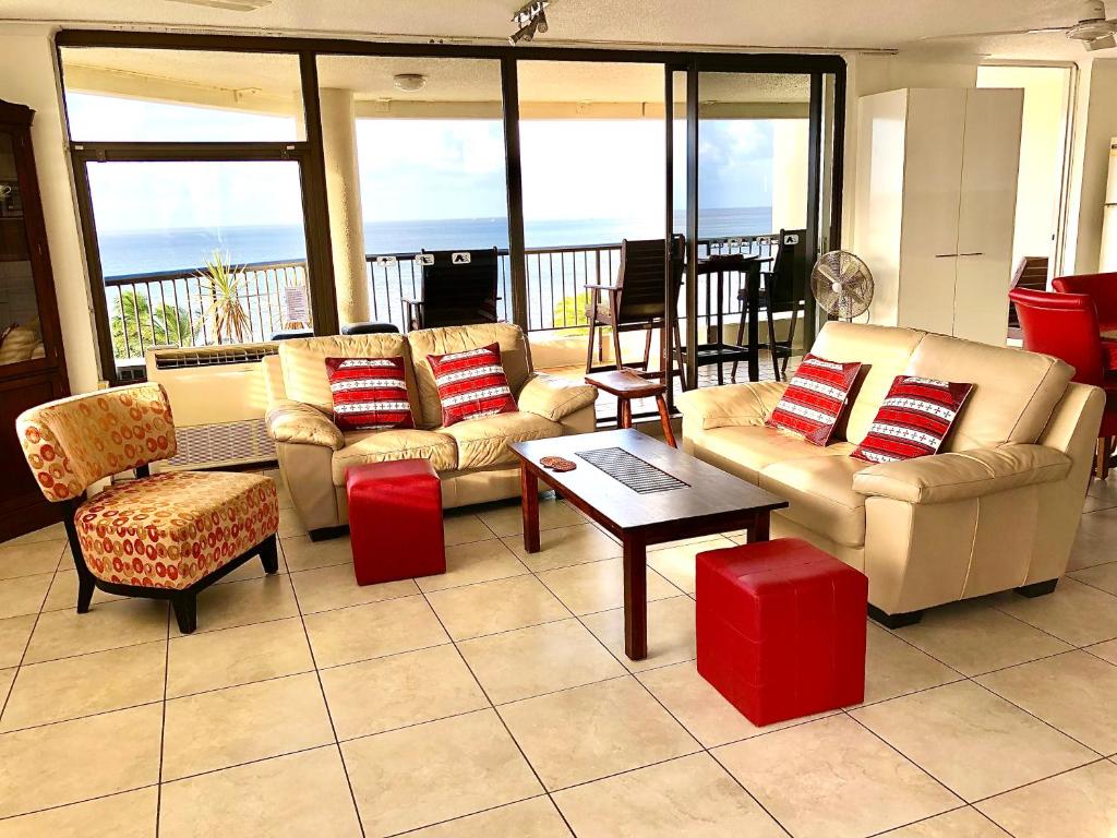 a living room with couches and a table and chairs at Cairns Apartment Esplanade Ocean Views in Cairns