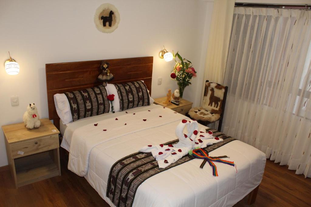 1 dormitorio con 1 cama grande con sábanas blancas en Cusco Hostal Qolla Wasi, en Cusco