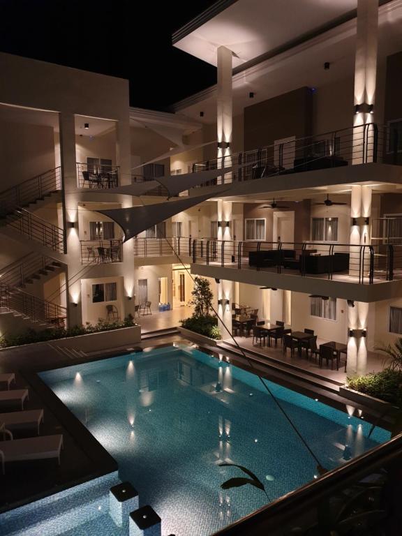 una piscina frente a un edificio por la noche en Rovira Suites, en Dumaguete