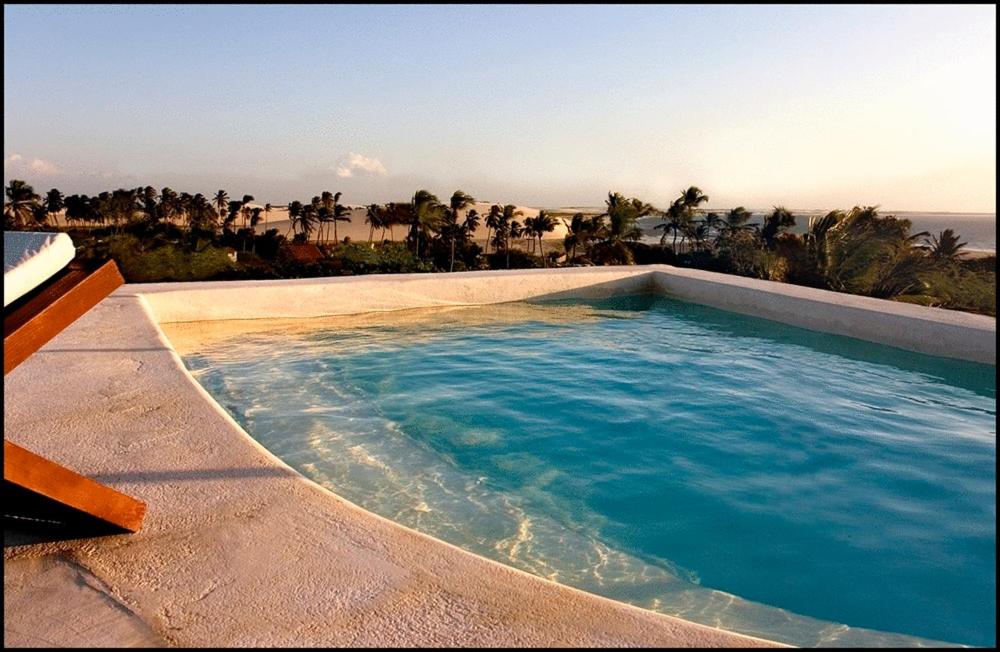 a swimming pool with a view of the ocean at All Blue in Jericoacoara