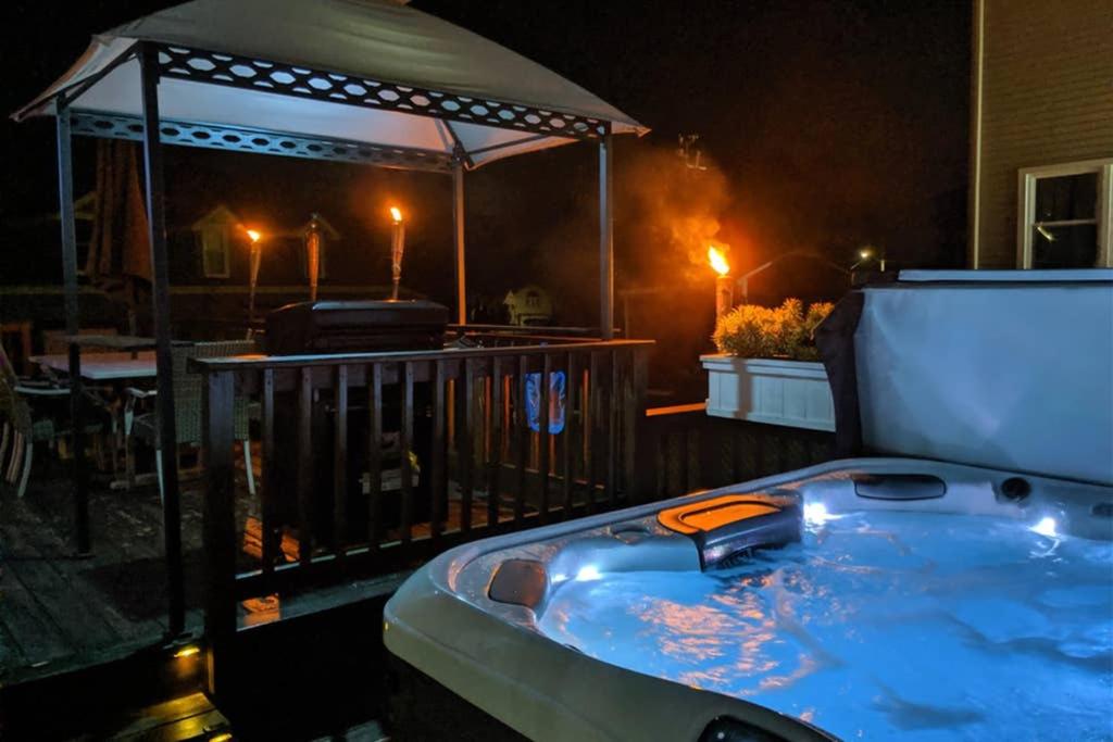 een hot tub in een prieel op een terras 's nachts bij Chain O Lakes Nautical 4Bed 3Bath Waterfront with Bonus Room, Large Deck and Hot Tub in Fox Lake