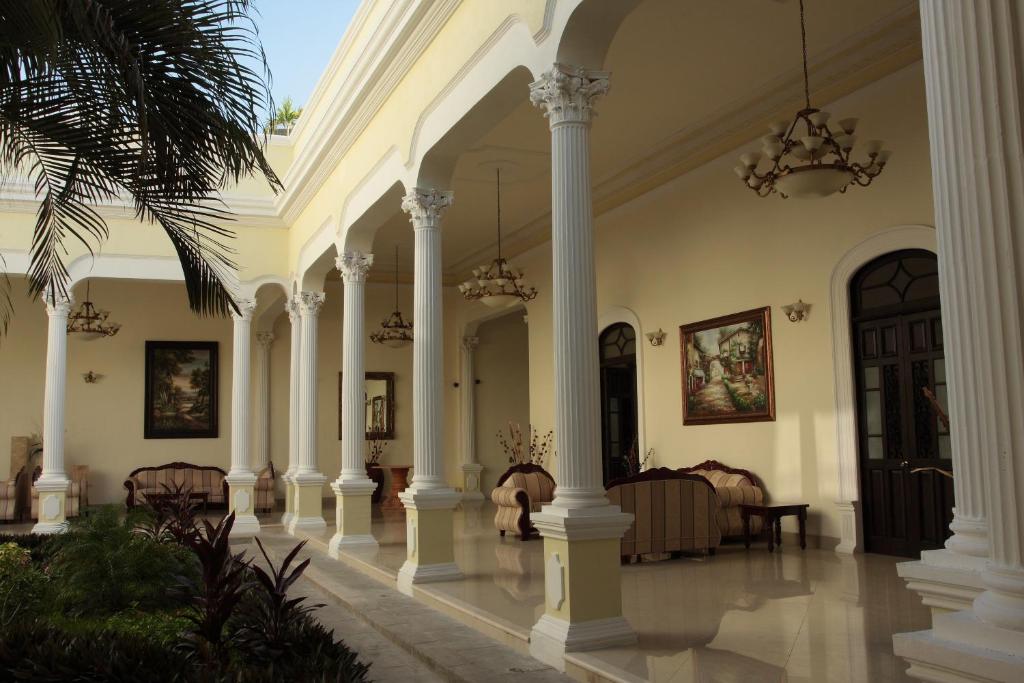 hol z kolumnami i żyrandolami w budynku w obiekcie Gran Real Yucatan w mieście Mérida