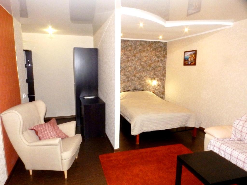 ノヴォクズネツクにあるApart Innのベッド、ソファ、椅子が備わる客室です。