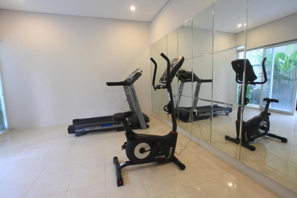 a gym with three exercise bikes and a mirror at Gaing Mas Jimbaran Villas by Gaing Mas Group in Jimbaran