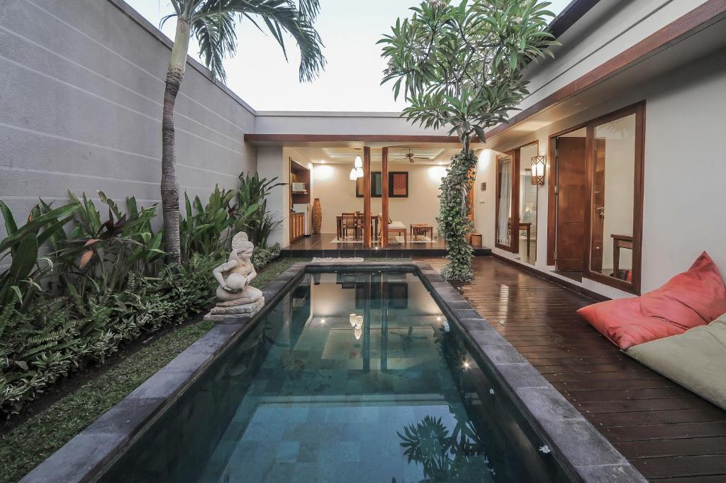 a swimming pool in the middle of a house at Gaing Mas Jimbaran Villas by Gaing Mas Group in Jimbaran