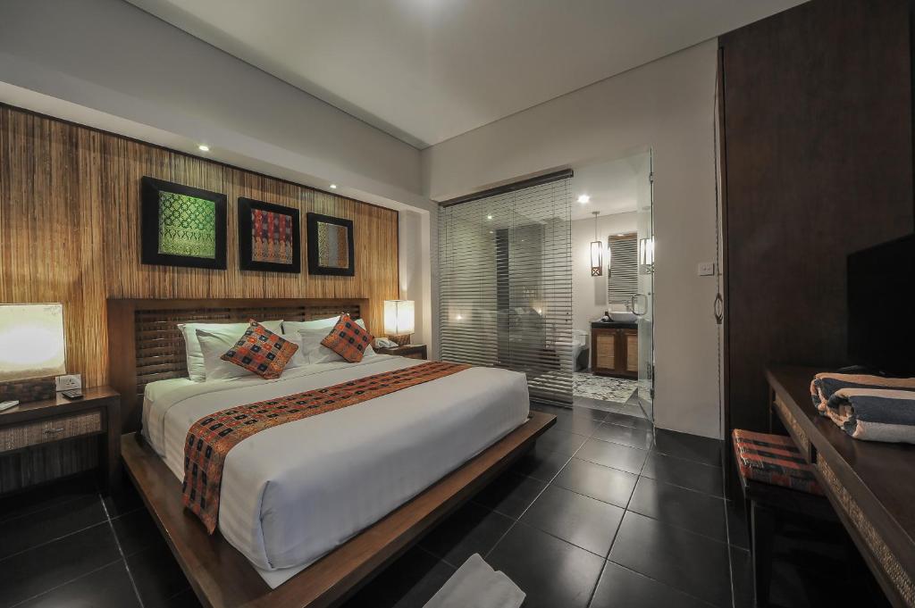 a bedroom with a large bed and a television at Gaing Mas Jimbaran Villas by Gaing Mas Group in Jimbaran