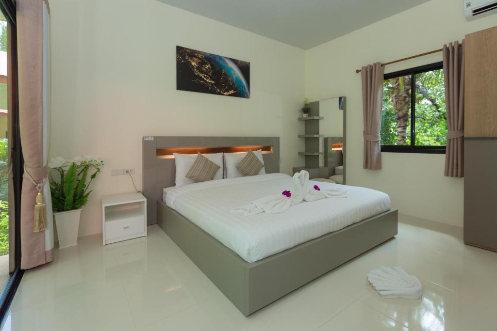 a bedroom with a large white bed in it at Garden Villa Khaolak in Khao Lak