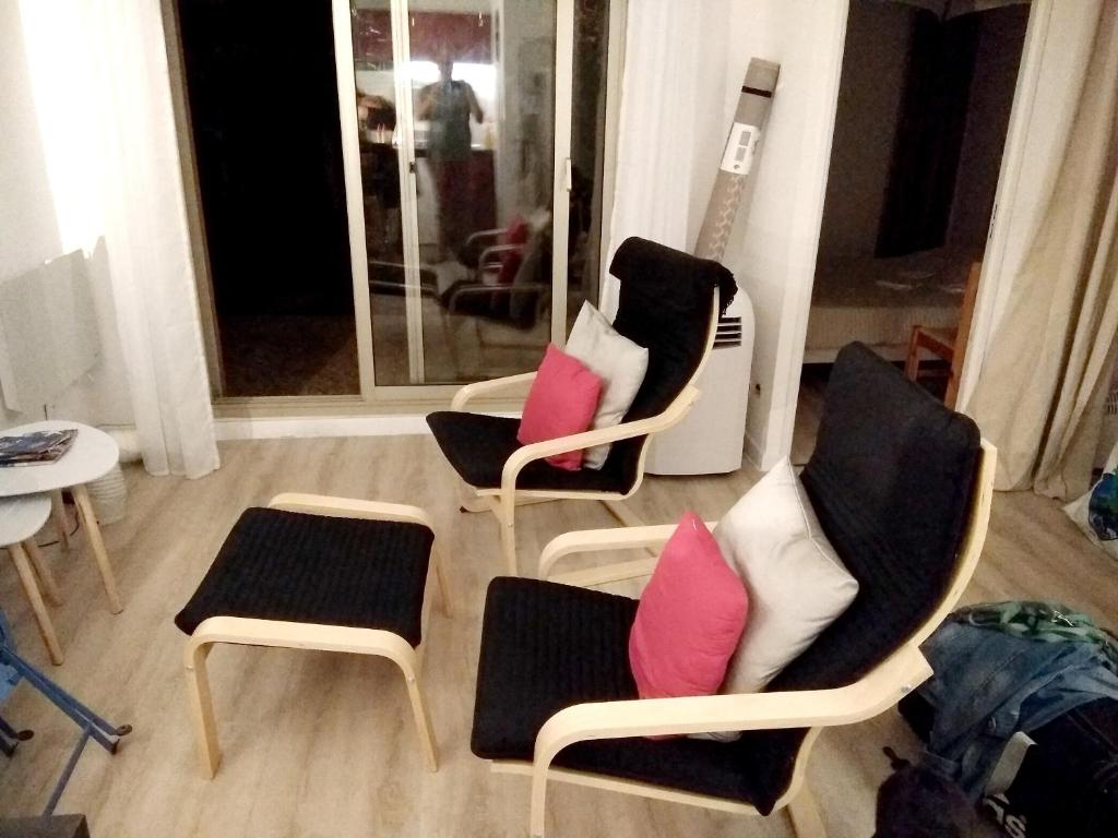 een groep stoelen met roze kussens in een kamer bij Charmant appartement à Cavalaire-sur-Mer avec terrasse in Cavalaire-sur-Mer