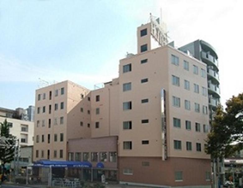 a tall white building with a sign on top of it at Hotel Kiyoshi Nagoya No.1 in Nagoya