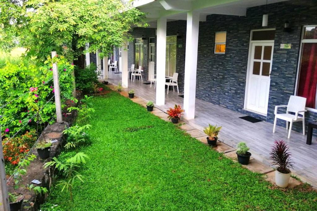 a porch of a house with a yard with plants at My Home Guest in Polonnaruwa