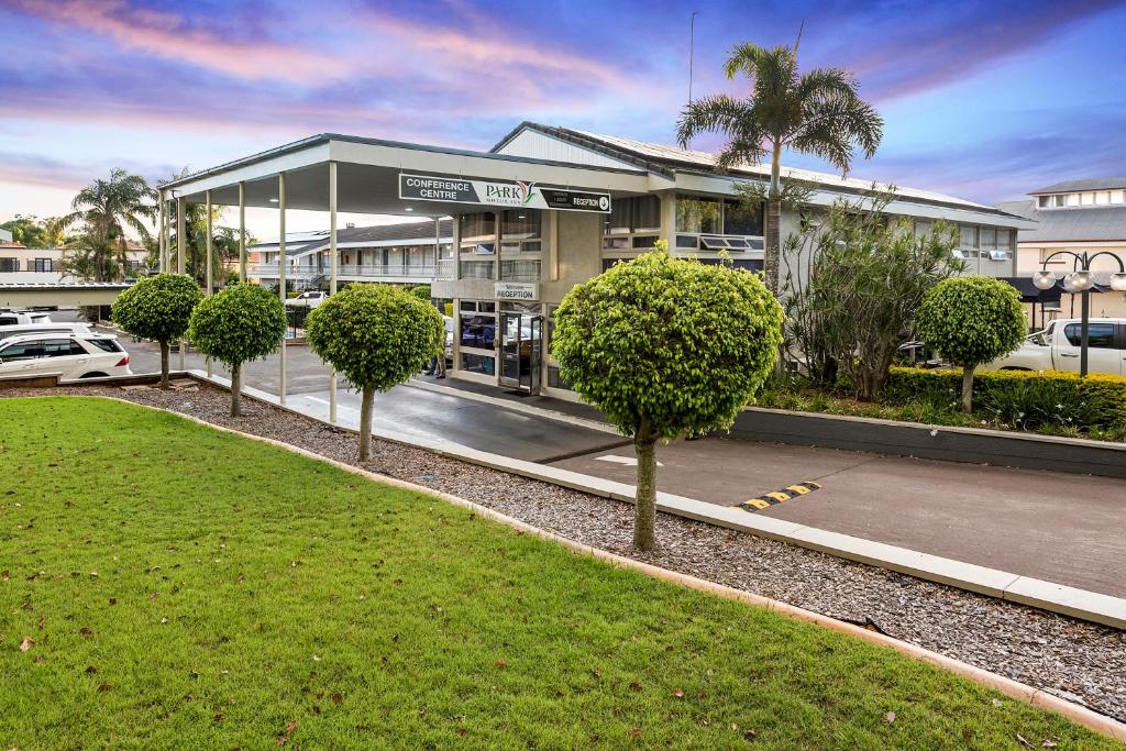 um edifício com uma fila de árvores à frente em Park Motor Inn em Toowoomba