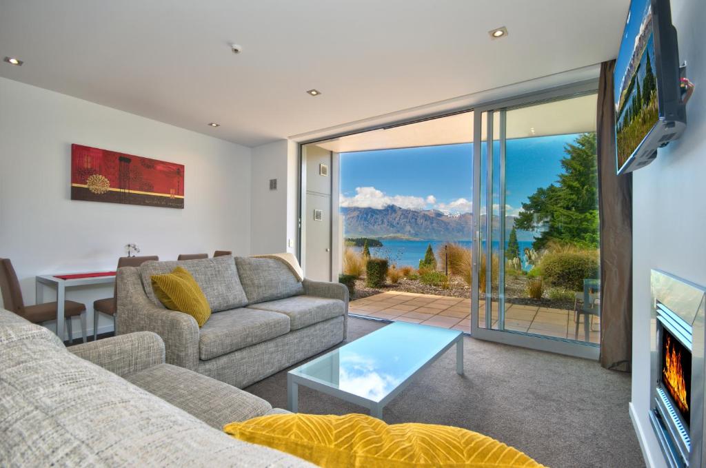 a living room with a couch and a view of the ocean at Lakes Edge Apartment in Queenstown