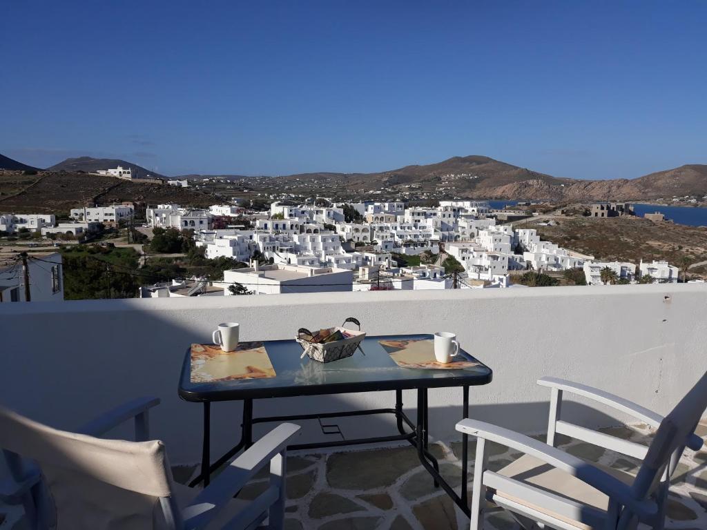 einen Tisch auf einem Balkon mit Stadtblick in der Unterkunft Athina's blue studios in Naoussa