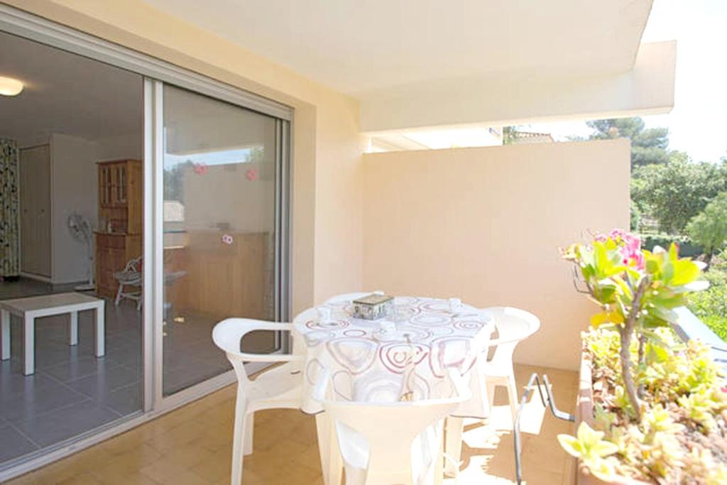 einen weißen Tisch und Stühle im Wohnzimmer in der Unterkunft Studio a Bormes les Mimosas a 400 m de la plage avec jardin clos et wifi in Bormes-les-Mimosas