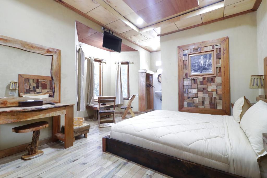 sypialnia z łóżkiem i biurkiem w obiekcie Alloyna Country Cottage Brastagi w mieście Berastagi