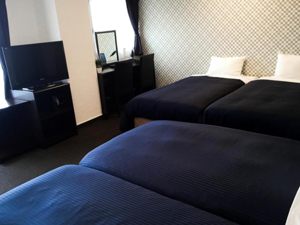 Postel nebo postele na pokoji v ubytování HOTEL LiVEMAX BUDGET Fuchu