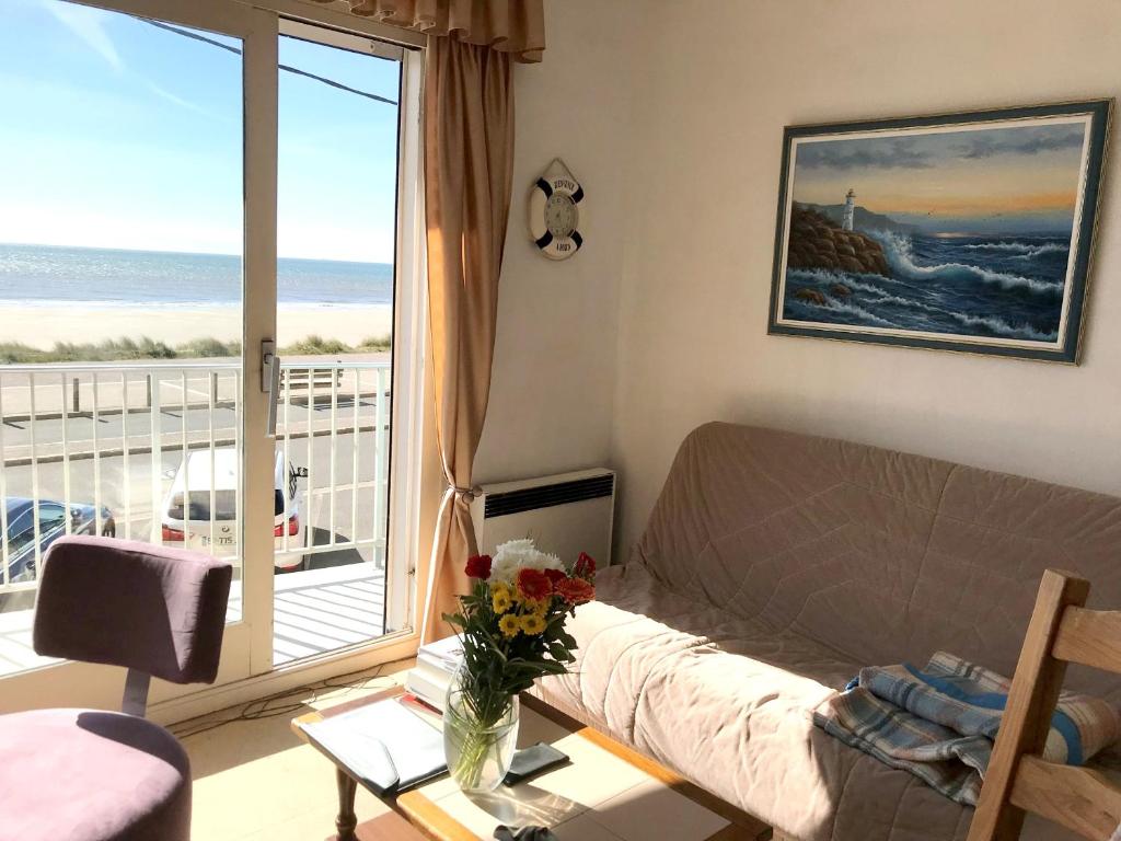 un salon avec un canapé et une vue sur l'océan dans l'établissement Appartement confortable avec vue sur la mer - Neufchâtel-Hardelot, à Neufchâtel-Hardelot