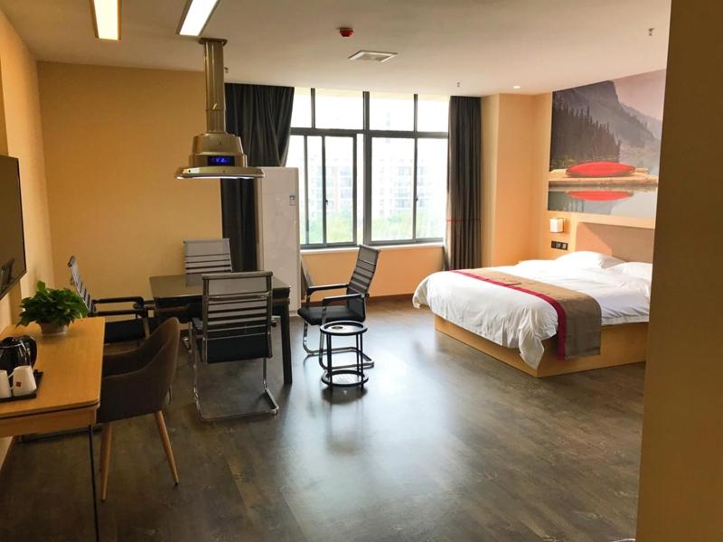 een hotelkamer met een bed, een bureau en een tafel bij Thank Inn Plus Hotel Hubei Xiaogan Nanda Economic Development Zone Tianxia Mansion in Xiaogan