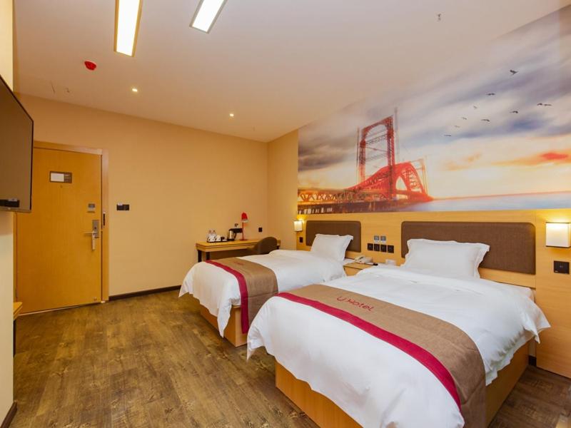 2 camas en una habitación de hotel con un cuadro en la pared en Thank Inn Plus Hotel Sichuan Chengdu Jianyang Dongcheng Huafu, en Chengdú