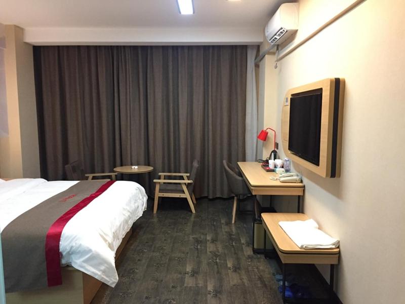 a hotel room with a bed and a desk and a television at Thank Inn Plus Hotel Guangxi Liuzhou Luzhai County Bus Station in Liuzhou