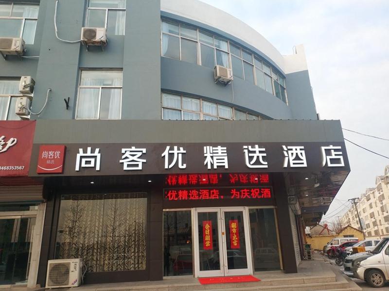 um edifício com escrita na parte da frente em Thank Inn Plus Hotel Shandong Rizhao Ju County Chengyang South RoadHospital of Chinese Traditional Medicine em Rizhao