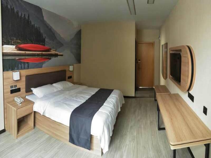 1 dormitorio con 1 cama grande y una pintura en la pared en Thank Inn Plus Hotel Anhui Chizhou Jiuhuashan Scenic Area Yonghua Road, en Chizhou