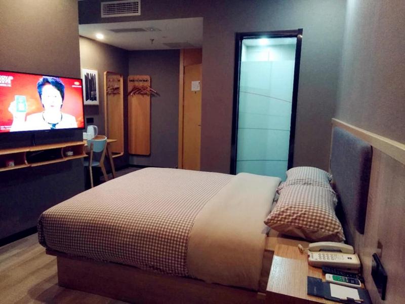 a bedroom with a bed and a tv in it at Up And In Hubei Suizhou Zengdu Qinghe Road Shengshihuating in Suizhou