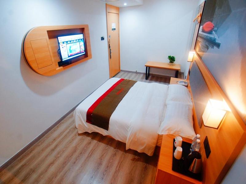 蘇州市にあるThank Inn Plus Hotel Jiangsu Suzhou Dushu Lake Dongxing Roadのベッドルーム1室(ベッド1台、壁掛けテレビ付)