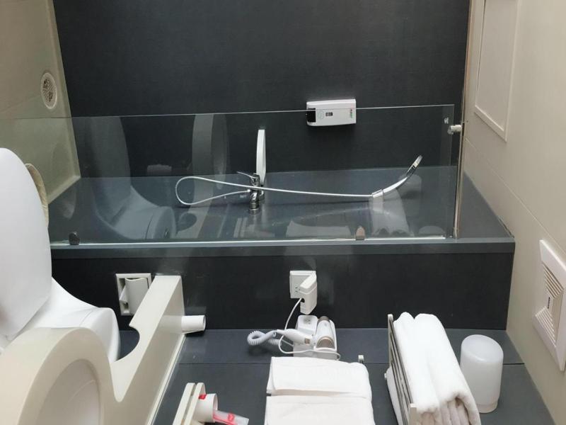 a bathroom with a sink and a toilet and a mirror at Thank Inn Plus Hotel Hebei Baoding Lixian County Liwu Street in Baoding