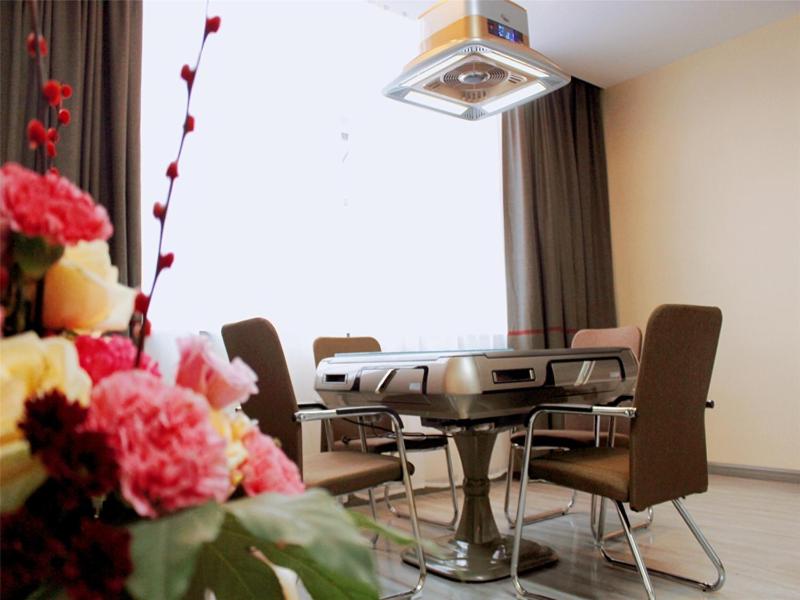 a dining room with a table and chairs and flowers at Thank Inn Plus Hotel Hubei Ezhou Echeng District Wuhan East Ocean World in Ezhou