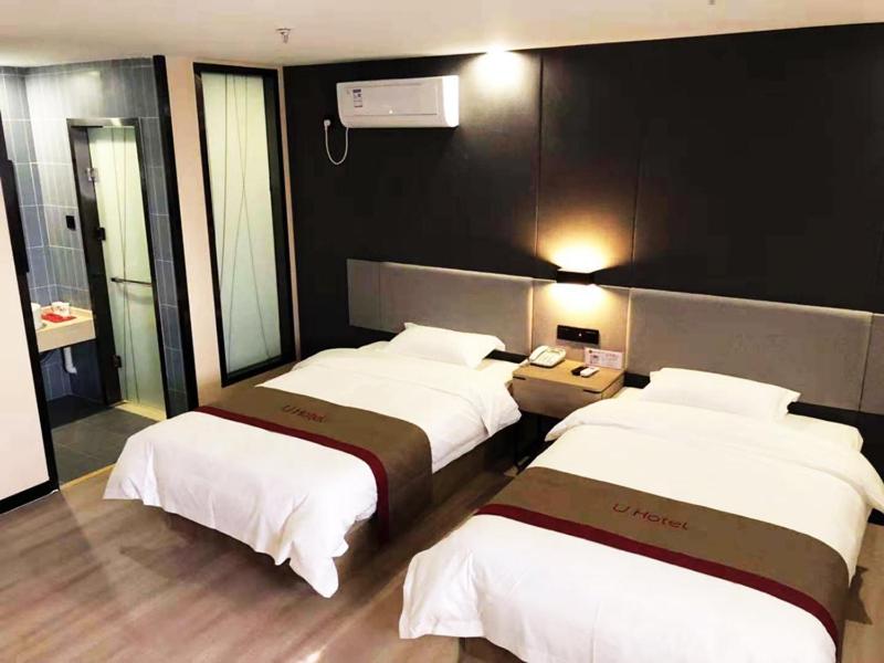 a hotel room with three beds and a phone at Thank Inn Plus Hotel Hebei Shijiazhuang Zhengding New District International Small Commodity City in Shijiazhuang