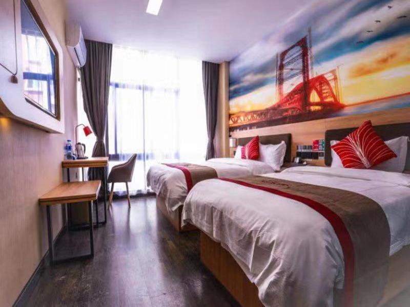 a hotel room with two beds and a desk at Thank Inn Plus Hotel Anhui Tongling Tongguan District Xihuchuncheng in Tongling