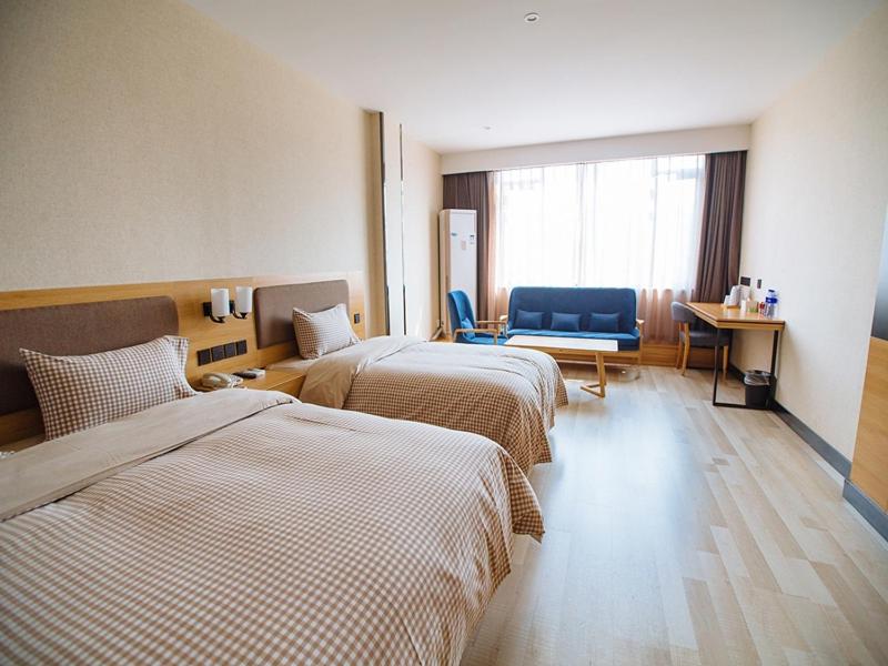 a hotel room with two beds and a window at Up And In Anhui Wuhu Anhui University of Engineering in Wuhu