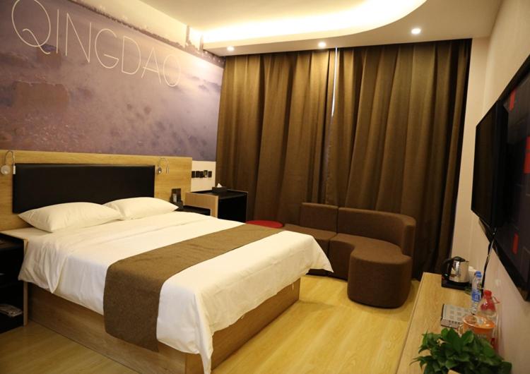 Habitación de hotel con cama y sofá en Thank Inn Plus Hotel Shandong Qingdao Jimo Development Zone New Government en Qingdao