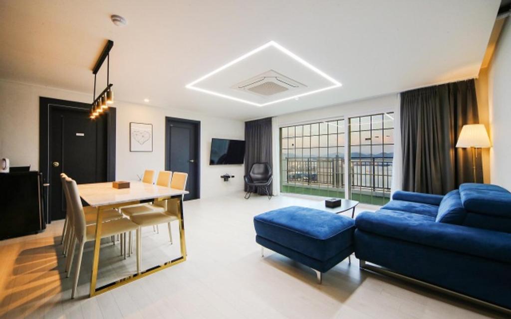 a living room with a blue couch and a table at Hotel Pier 48 in Tongyeong