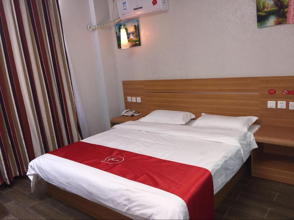 a hotel room with a bed with a red blanket at Thank Inn Plus Hotel Shandong Zaozhuang Tengzhou Parallel Road Qinghe Shangcheng Community in Zaozhuang