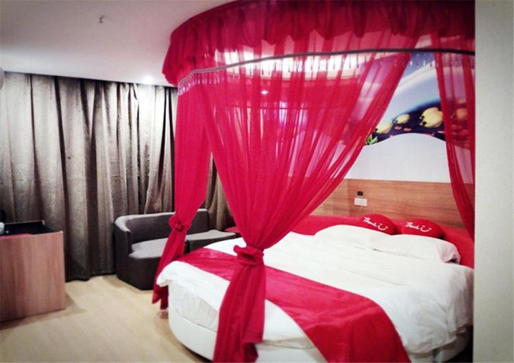 1 dormitorio con cama roja y cortina roja en Thank Inn Plus Jiangxi Jingdezhen Fuliangxian Hongyuanzhen Beiqizhudi en Jingdezhen