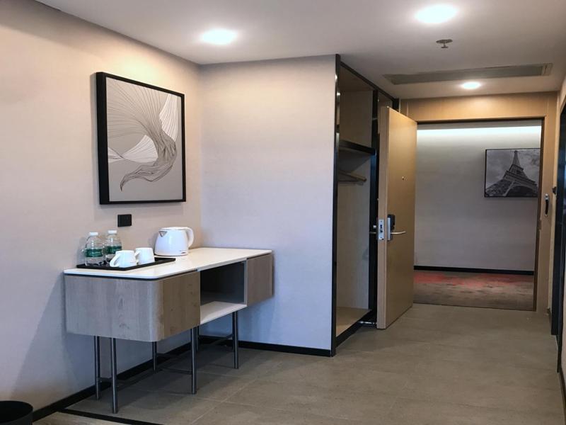 a room with a desk and a hallway with a door at Up And In Guangdong Zhongshan West District Caihong Street in Zhongshan