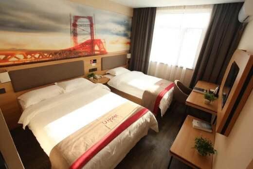 a hotel room with two beds and a window at Thank Inn Plus Hotel Shandong Rizhao Donggang District Lighthouse Plaza in Rizhao