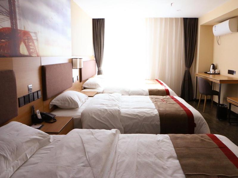 a hotel room with two beds and a desk at Thank Inn Plus Hotel Shanxi Jinzhong Yuci District Yingbin West Street Yinhaixinyue in Jinzhong