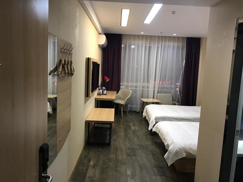 a hotel room with two beds and a table and a desk at Thank Inn Plus Hotel Jiangsu Taizhou Gaogang Port Middle School in Taizhou