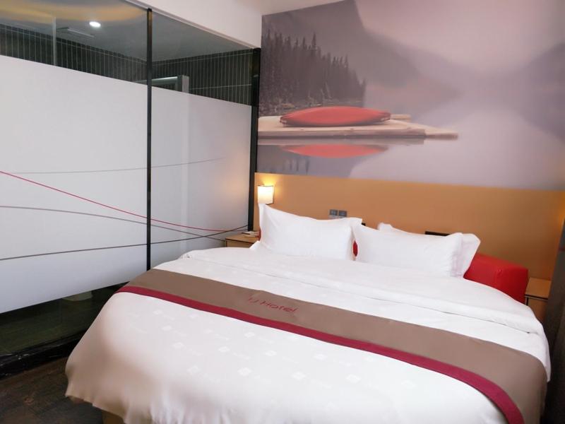 1 dormitorio con 1 cama grande y una pintura en la pared en Thank Inn Plus Hotel Hubei Suizhou Zengdu District Mingzhu Plaza, en Suizhou