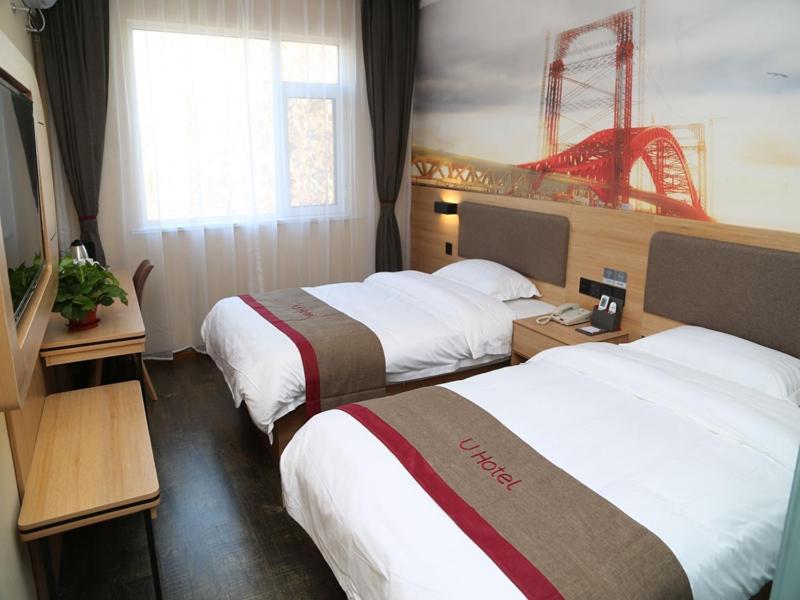 a hotel room with two beds and a simulator at Thank Inn Plus Hotel Shandong Weifang Shouguang City Shengcheng Street Daily Newspaper Office in Weifang