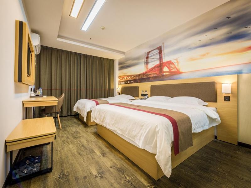 a hotel room with two beds and a desk at Thank Inn Plus Hotel Jiangxi Ganzhou Nankang District East Bus station in Ganzhou