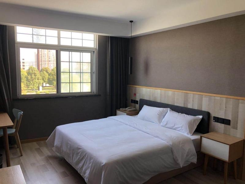 Un dormitorio con una gran cama blanca y una ventana en Up And In HuBei Jingzhou Jiangling xian Jiangling Road, en Jingzhou