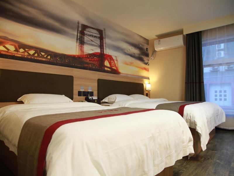 two beds in a hotel room with a bridge on the wall at Thank Inn Plus Hotel Shandong Jining Qufu City Sankong Tourist Center in Jining